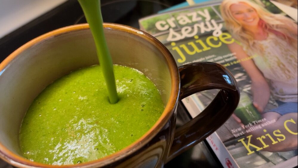 Pouring a green blend into a mug